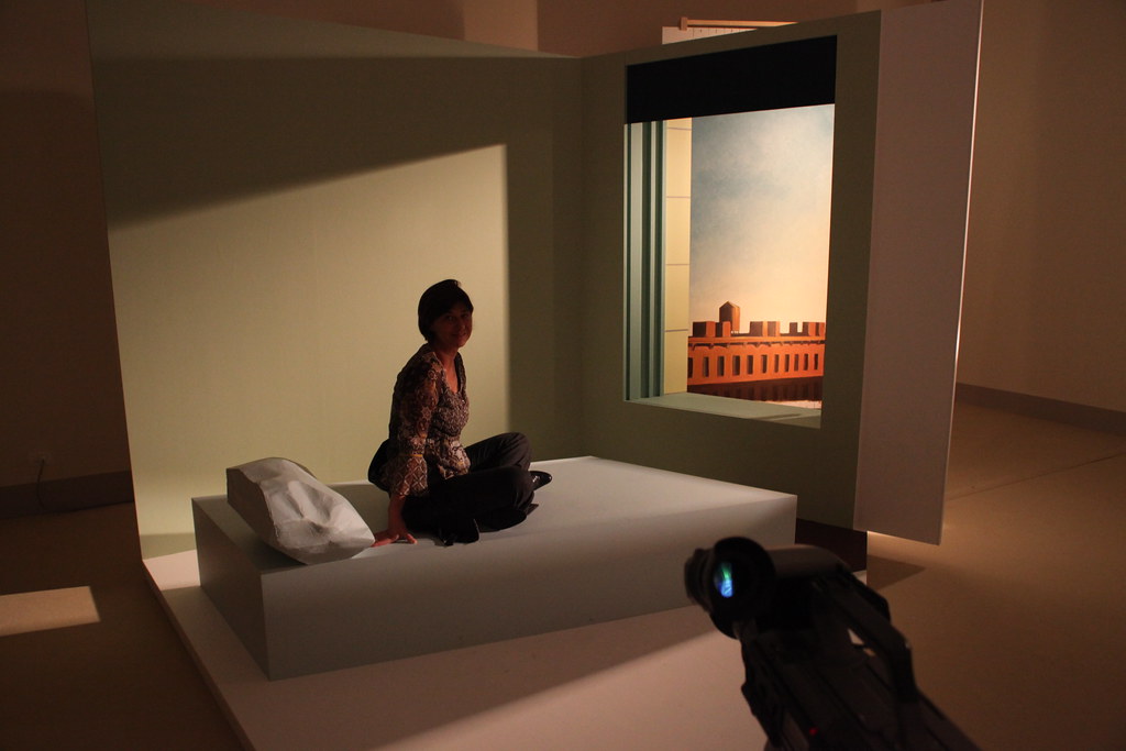 Visitors beside a bed in an art exhibition