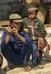 Hani man and child with military hat; Market at Menghum, Xishuangbanna, Yunnan, China