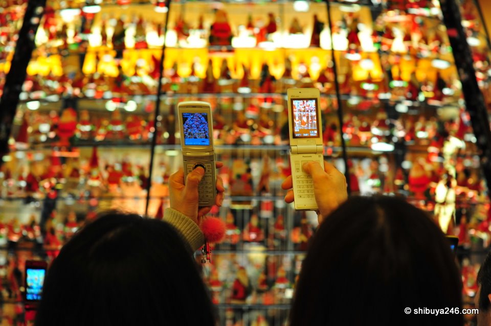 2 friends snapping their mobile phones in unison. Taking photos with mobiles has almost become a "thing" to do.