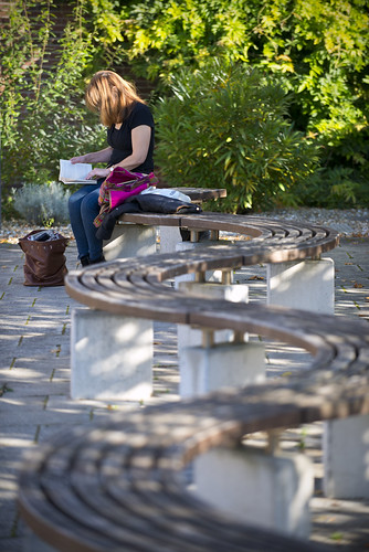Female Reading on Plaza Curved Bench Exterior UNI_7957