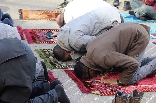 Men practice Salah in front of Amazon