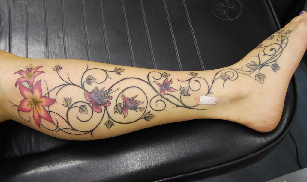 lilys, orchids and vines tattoo on leg and foot.