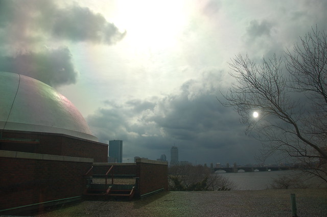 Skies opening up over the planetarium dome at the Museum of Science, looking over Back Bay Boston and the Longfellow Bridge