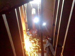 Workers using blowtorch to break apart the ship