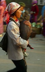 Woman with piglet in arms; Market at Menghum, Xishuangbanna, Yunnan, China