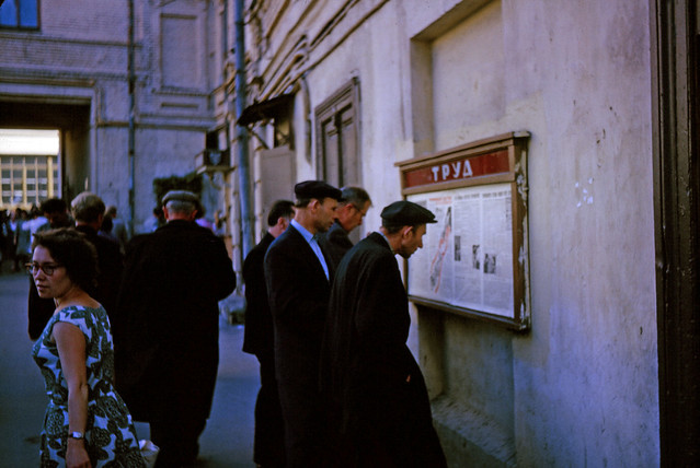 Soviet men reading a notice board