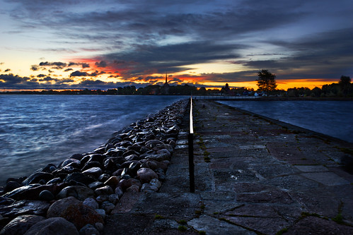 Leading into the sunrise by imagesbystefan.com, standing in the end of an pier overlooking the sun rise an early autumn morning in Vadstena Sweden.
