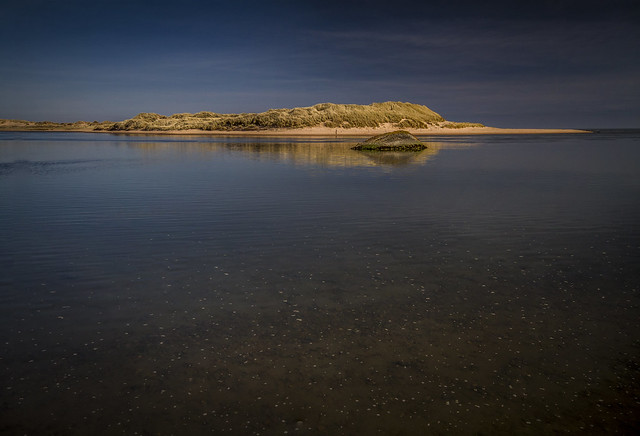 glowing colours of wreck and sand dune, dark waters at Sands of Forvie Nature Reserve, Newburgh, Aberdeenshire, Scotland