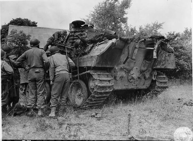 US soldier inspecting a burnt german Panther tank in Falaise,France 1944.
