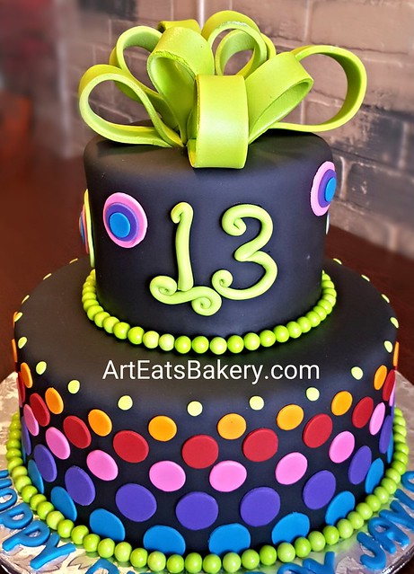 Girl's custom black fondant 13th birthday cake with bright colored polka dots, edible bow and chocolate pearls. Http://www.arteatsbakery.com #cake #birthday #girl #greenville