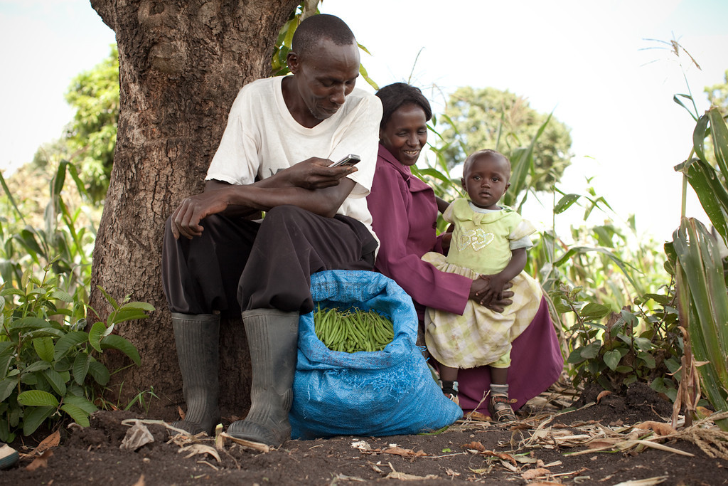 photo a Kenyan farming family sitting under a tree