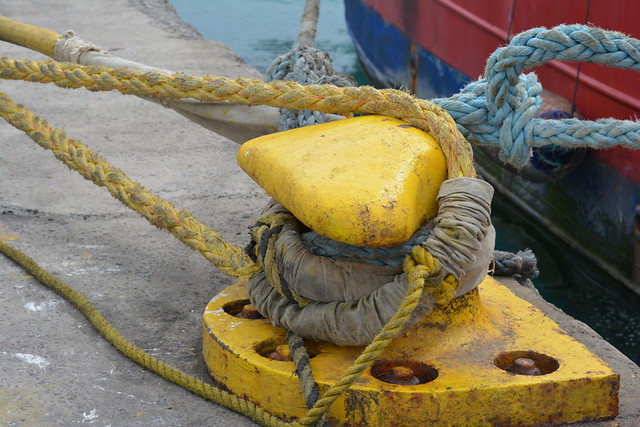 ROPE CLEAT AND ROPE...COLORFUL ON THE DOCK.  SHIPS BOW,  IN  MINDELO BAY,  CAPE VERDE.