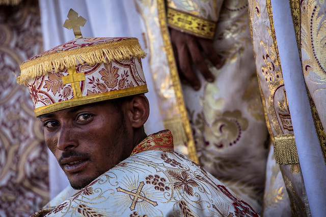 priest with the colorful umbrella outside the St. Mary Zion Church in axum, tigray