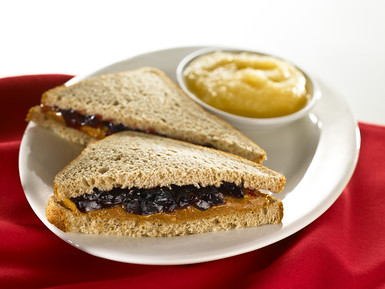 spreading grape jelly on bread