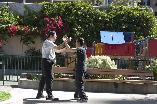 Chinese Men practicing martial arts in Saint Mary's Square, Chinatown, San Francisco, California, USA