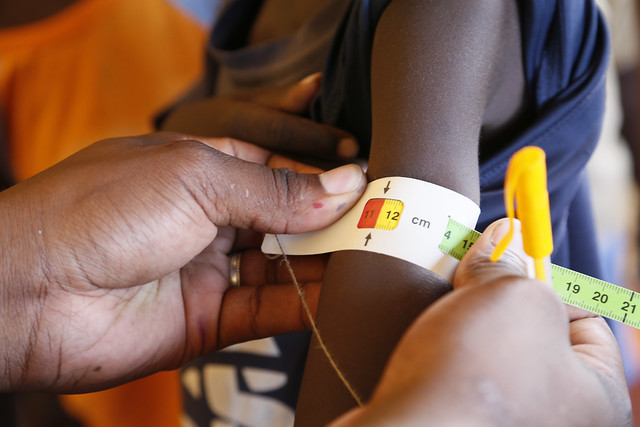 International Rescue Committee staff measure the upper arm circumference of 7-year-old Ngikadelio Ngikeny as part of a malnutrition screening programme, at a health clinic in Turkana County, northwest Kenya, 29 March 2017.