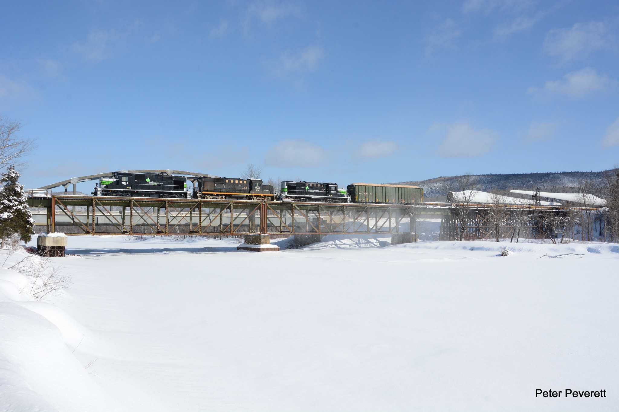 From the winter of 2006 to the winter of 2017 there was not much freight traffic at all on the Gaspe Peninsula . All that was left for the most part was lumber and wood chips from Nouvelle, Quebec.  East of there not much at all.  After years of talks and hope about new business it finally came to be in the form of wind mill parts from a company in Gaspe.  In the company of friends it was great to witness the third train hauling windmill parts depart from New Richmond, Quebec on March 4, 2017. Societe du Chemin De Fer De La Gaspesie RS-18 # 1819, 1865, 1856 have the train of 72 flats underway at Grand Cascapedia, Quebec crossing the Cascapedia River. 