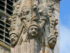 three faces on a porch turret