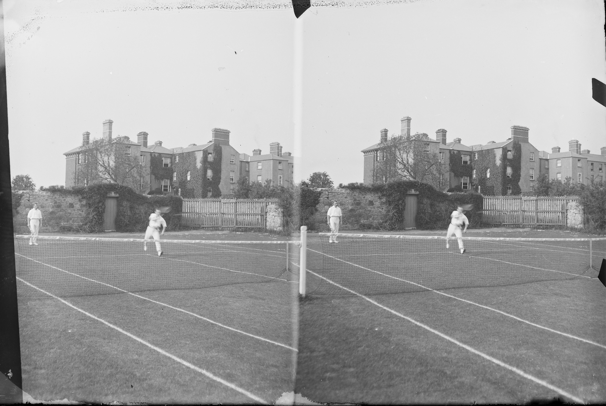 Stereo view of tennis court with a doubles match taking place, large house in the background