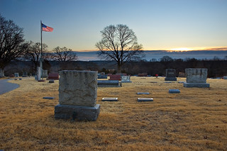 Flag over cemetery at sunrise