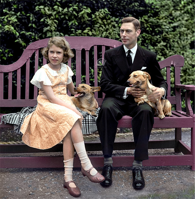 July 1936: King George VI and then Princess Elizabeth sitting on a bench with their corgi dogs in the grounds of their London home.