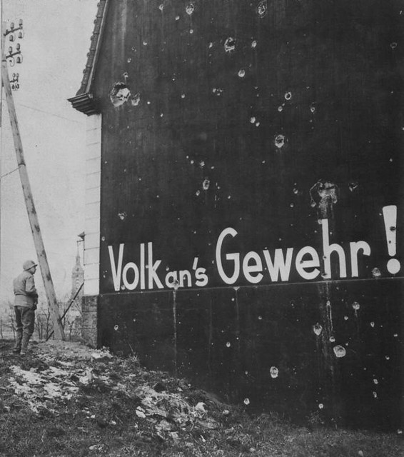 1945, Allemagne, Un soldats Us regarde une inscription sur un mur 