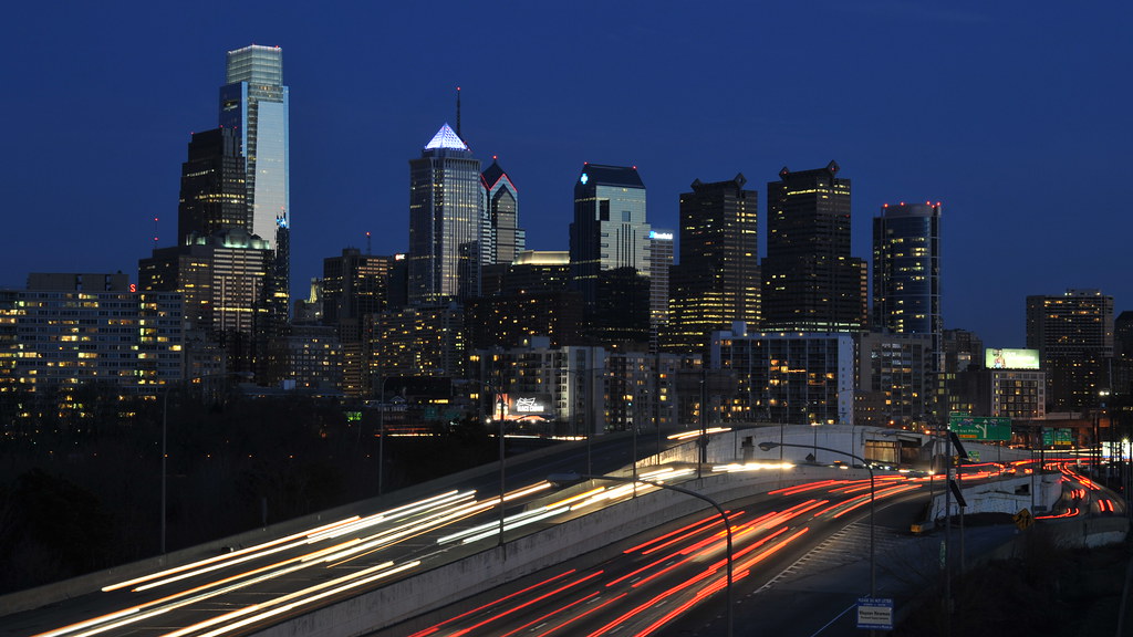 Philadelphia skyline beside a road with light trails