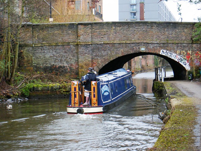 Manchester canal with narrow boat and bridge