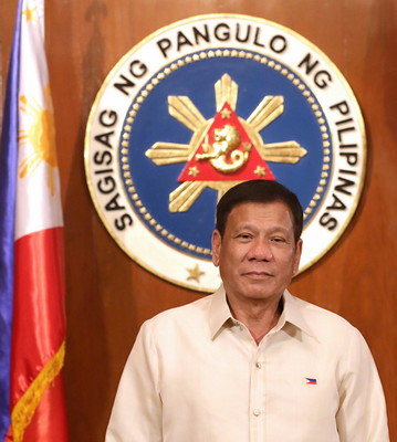 The image shows President Rodrigo Duterte Standing in front of the wooden wall with the logo of Sagisag ng Pangulo ng Pilipinas and Philippine Flag shown at the left side.