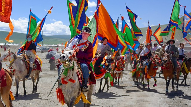 Flag bearers on horses in front of the Sershul temple, Tibet 2014