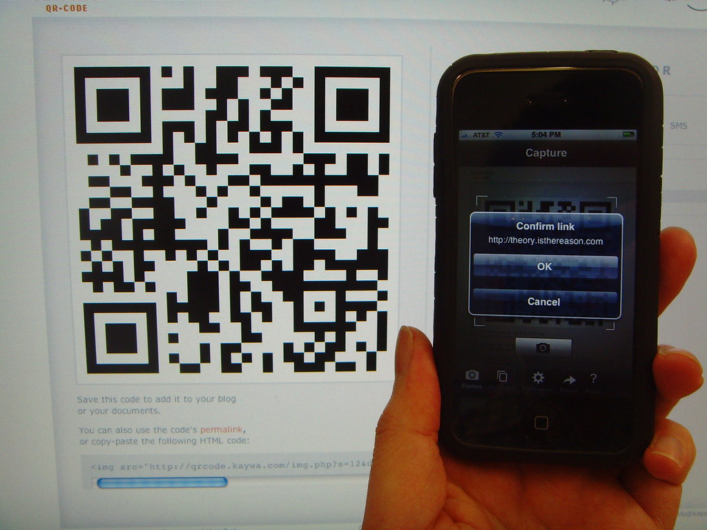 How to Generate and Read QR Code - a person holding a cell phone in their hand