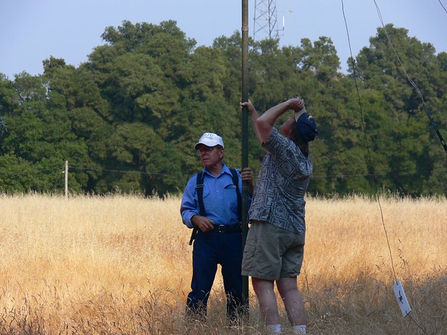 2 men holding mast pole