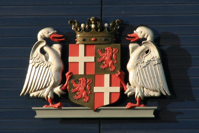 Coat of arms, held up by two swans who just returned from a party