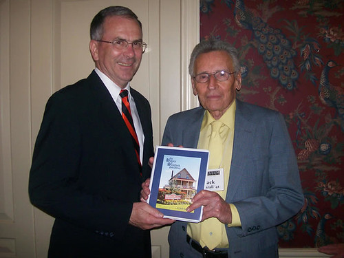 Dr. Russell Nichols receiving a book written by Jack Cathrall