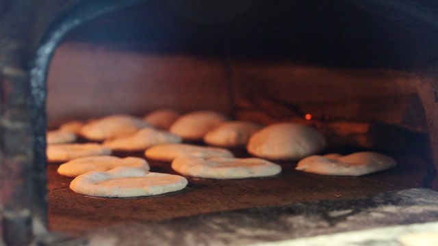 Baking fresh pita in a wood fired oven