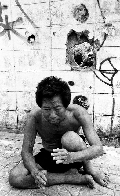 Street person and hole in the wall - Bangkok, city of angels