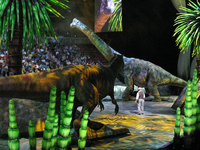 Allosaur watches a young Brachiosaur