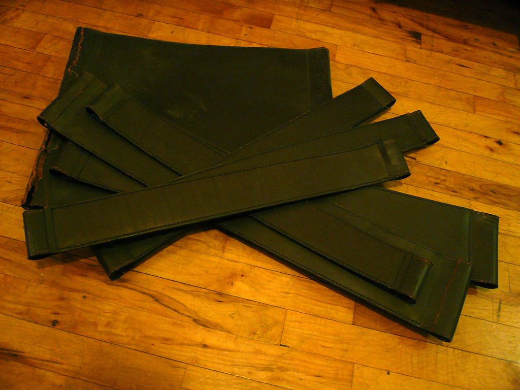 marcel breuer chaise wassily (en morceaux) : des morceaux de tissu sombre reposent sur un plancher de bois franc.