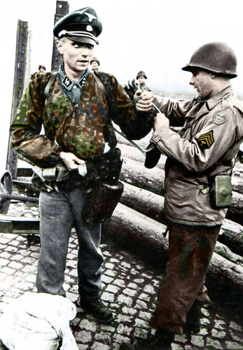 An Untersturmführer (2nd Lieutenant) of the Waffen-SS is searched by an american soldier straight after being captured. The G.I. is just taking the officers' watch