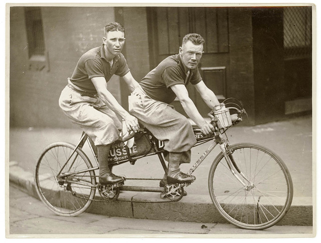 Two men in plus-fours on a tandem, by Sam Hood