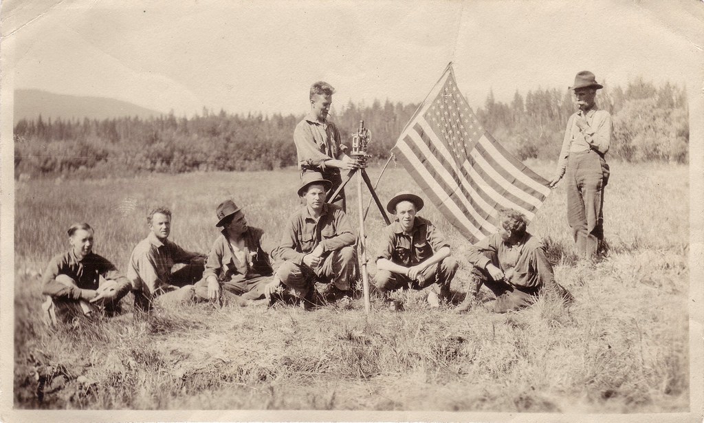 Surveyors with theodolite & US flag