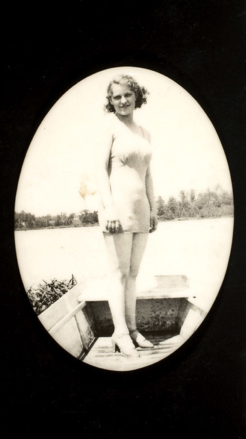Woman in boat wearing bathing suit and high heels
