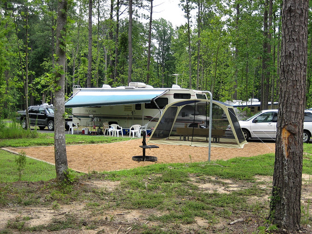Chippokes State Park campground with an RV at it with trees surrounding it and a sandpad with a bug net on it