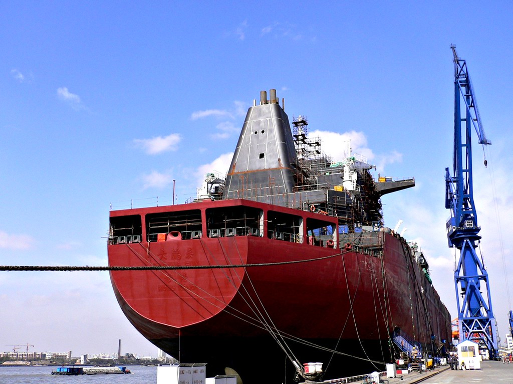 The LNG carrier Dapeng Sun at a shipyard in Shanghai, its hull and cargo domes under a crane