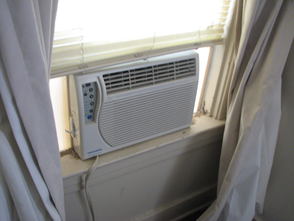 Window air conditioner - a window with a white curtain