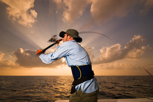 Maldives Islands, Indian Ocean. A fisherman casting his lure with the sunset behind him. Lighting with 3 bare speedlights