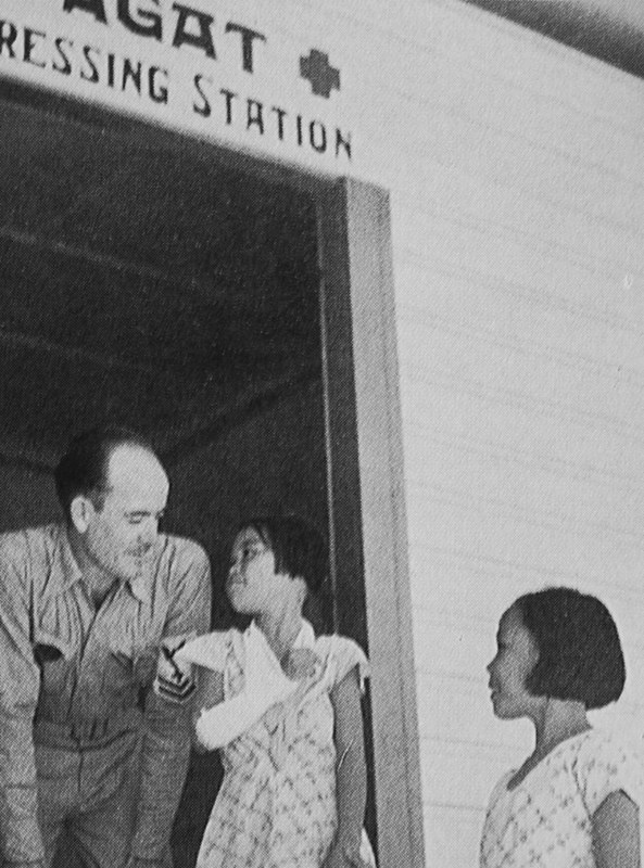 Corpsman W.R. Lamson talks to Ester Carbullido after tending to her arm. Her sister Caroline is present to escort her home. Photo from the National Geographic courtesy of Don Farrell.
