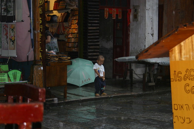 Boy pissing in the street, Yangshou, China