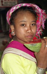 Pretty girl eating watermelon, notice her earrings; Menghum, Xishuangbanna, Yunnan, China