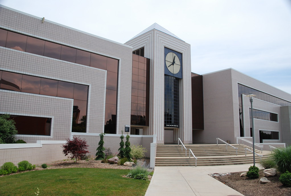 western michigan university library--a three story rectangular building made of brown brick and copper siding, with a flight of stairs leading up to a clock tower